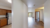 Located at 1830 N Delany Rd in Gurnee, IL, this 2-bedroom, 2-bathroom unit offers a practical and well-appointed single-floor layout. The kitchen is equipped with warm honey-toned wood cabinetry, granite-style laminate countertops, stainless steel appliances including an electric range and dishwasher, and tile flooring — all centered around a pass-through window that connects to the dining area. The adjoining living room features light gray luxury vinyl plank flooring, a ceiling fan, a baseboard heating unit, and a sliding glass door that opens onto a private balcony overlooking lush, mature trees. Both bedrooms include LVP flooring, individual wall-mounted AC units, natural light from windows with blinds, and double-door closets offering generous storage. The primary bedroom is a comfortable, well-sized retreat. A dining area with tile flooring leads conveniently to additional storage space. The two bathrooms are clean and functional — one features classic white subway tile surrounding a soaking tub with a showerhead and chrome fixtures, while the second offers a matching tub-shower combo with white tile, a wood-toned vanity, and stone-look flooring. Textured ceilings are consistent throughout, adding a familiar residential character to this well-maintained Gurnee home.