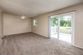 This one-bedroom, one-bathroom home in Burlington, Iowa offers a practical and comfortable single-floor layout. The living room is a bright, open space featuring carpet flooring, a ceiling fan, and large sliding glass doors that open onto an outdoor deck — filling the room with natural light and providing easy access to the outdoors. A second window adds to the airy feel of the space. The living room connects through a hallway to the rest of the home, with convenient ceiling fan fixtures throughout. The galley-style kitchen is well-equipped with dark wood cabinetry, light granite-style countertops, a double-basin sink, a gas range, and a full-size refrigerator. Tile flooring and ample upper and lower cabinet storage make this kitchen both functional and efficient. The bedroom is a comfortable, carpeted retreat with a large window offering views of the surrounding neighborhood and direct access to a spacious walk-in closet. The full bathroom features a single-sink vanity with a granite-style countertop, wood cabinetry, tile flooring, and a tub-shower combination. The home also benefits from four closets in total, providing generous storage throughout.