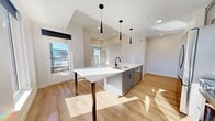 This contemporary 870 square foot apartment in Denver offers a blend of style and functionality. The open-concept design maximizes the use of space, creating a seamless flow between the living areas. Large windows throughout flood the rooms with natural light and provide stunning city views, enhancing the urban living experience.

The kitchen is a highlight, featuring sleek gray cabinetry, stainless steel appliances, and a spacious island with seating, perfect for casual dining or entertaining. Modern pendant lighting adds a touch of elegance to the space.

The apartment boasts three bedrooms, including a primary bedroom of 150 square feet, offering ample space for rest and relaxation. Two well-appointed bathrooms feature clean lines, with one showcasing a double vanity and large mirror.

Hardwood floors run throughout the living areas and bedrooms, adding warmth and continuity to the space. The neutral color palette creates a canvas for personal style while maintaining a modern aesthetic.

Additional features include a closet for storage and in-unit laundry facilities. The apartment's location at 855 N Broadway places residents in the heart of Denver, with easy access to urban amenities and transportation.

This apartment combines comfort, style, and location, making it an ideal choice for those seeking a contemporary urban lifestyle in Denver.