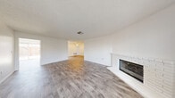 Located at 1101 N Rainbow Blvd in Las Vegas, NV, this single-story, 2-bedroom, 2-bathroom home offers a practical and well-organized layout. The open living area is a standout feature, with light wood-tone flooring flowing throughout and a white brick fireplace serving as a focal point. A ceiling fan is visible in the adjoining space, and textured ceilings add a classic touch. Natural light filters in through windows, keeping the interior bright and airy.

The combined dining room and kitchen area is equipped with warm wood cabinetry offering ample storage, white countertops, and white appliances including a refrigerator, electric range, and over-the-range microwave. The kitchen maintains a clean, functional aesthetic.

Both bedrooms feature the same light wood-tone flooring, neutral white walls, and ceiling fans with lighting. The spacious primary bedroom provides generous room for furnishings. Each bedroom is supported by dedicated closets. The two bathrooms include a stall shower with a sliding frosted-glass door in at least one unit.

The attached garage features a clean epoxy-coated floor and a wood-paneled ceiling, offering practical vehicle and storage space. A private patio rounds out the home's outdoor amenities, adding additional space for relaxation or outdoor activities.