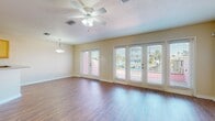 This single-story home at 929 Apollo Beach Blvd offers a well-designed, open-concept layout with consistent finishes throughout. The main living area is a spacious, light-filled space featuring warm hardwood-style flooring, a textured ceiling, and a ceiling fan with integrated lighting. Multiple French doors line the exterior wall, flooding the room with natural light and providing access to the outdoors. An adjacent dining area connects seamlessly to the kitchen, which is equipped with honey-toned wood cabinetry, granite-style countertops, stainless steel appliances including a range, microwave, and dishwasher, and light tile flooring. A breakfast bar provides additional counter space and casual seating.

The bedrooms are carpeted and bright, each featuring ceiling fans and windows with blinds that allow for natural light and outdoor views. Ample storage is provided through walk-in closets fitted with wire shelving systems. The bathrooms are finished with neutral tile flooring and walls. A secondary bathroom includes a vanity with a granite-style countertop and warm wood cabinetry, while the primary bathroom features a corner soaking tub and a separate glass-enclosed shower, both finished in coordinating beige tile. Overall, the home presents a cohesive, functional design suited to Florida living.