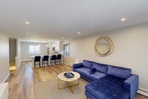 Located at 200 La Bonne Vie Dr in East Patchogue, NY, this two-story, one-bedroom, one-bathroom home offers a well-organized and functional layout across two floors. The main level hosts a generously sized open-plan kitchen and living area finished with light wood-style flooring throughout. The kitchen is equipped with stainless steel appliances, crisp white shaker cabinetry, granite-style countertops, and a peninsula with bar seating — ideal for both cooking and casual dining. Recessed lighting and pendant fixtures keep the space bright and inviting. The living area extends comfortably toward sliding glass doors that open to the outdoors, filling the room with natural light. A staircase with natural wood treads and a white railing connects the main level to the upper floor, where the spacious primary bedroom is found. The bedroom features plush carpeting, a ceiling fan, a natural-light window, and two closets, providing ample storage. The full bathroom is elegantly appointed with large-format neutral tile surrounding a soaking tub with an overhead rain shower, chrome fixtures, and a marble-topped vanity. The overall aesthetic is clean, modern, and move-in ready.