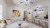 Located at 2004 S Mustang Rd in Oklahoma City, Oklahoma, this 1-bedroom, 1-bathroom residence offers a thoughtfully designed single-floor layout that maximizes functionality and comfort. The open-concept living area greets you with warm neutral tones, plush carpeting, crown molding, and a ceiling fan overhead. Natural light filters in through slatted blinds, creating a bright and welcoming atmosphere. The living room flows seamlessly into the kitchen, which features white cabinetry, a breakfast bar with counter seating, and standard appliances — ideal for casual dining and entertaining. A private bedroom provides a comfortable retreat, complete with its own ceiling fan, a window with outdoor views, and a dedicated closet for ample storage. The bathroom is clean and functional, offering a vanity with white cabinetry, tile flooring, and a well-lit mirror. Additional conveniences include an in-unit laundry area, making day-to-day living practical. Throughout the space, consistent neutral wall tones and carpeted floors lend a cohesive, move-in-ready feel. The compact yet efficient layout makes excellent use of every square foot, delivering a comfortable living experience in a well-connected Oklahoma City location.