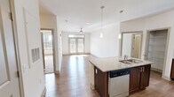 Located at 811 Evolve Way in Knoxville, TN, this single-floor, 2-bedroom, 2-bathroom residence offers a thoughtfully designed open-concept layout with modern finishes throughout. The living area is bright and welcoming, featuring hardwood-style flooring, a ceiling fan, and French doors that invite an abundance of natural light. The kitchen is a standout, boasting rich dark-wood cabinetry, granite countertops, a subway tile backsplash, stainless steel appliances including a range, microwave, and refrigerator, a peninsula with pendant lighting and a built-in sink, and a walk-in pantry with wire shelving. Both bedrooms are carpeted and include ceiling fans and windows that allow natural light to fill the space. The generously sized primary bedroom offers a comfortable retreat. The two bathrooms are finished with wood-look tile flooring and dark-wood vanities; one features a glass-enclosed walk-in shower, while the other includes a vanity with ample storage. Additional highlights include two closets, a dedicated laundry room with washer and dryer hookups, and a hallway connecting all areas seamlessly. The clean, neutral color palette throughout lends the space a versatile and modern ambiance.