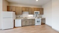 This 500 square foot apartment in Boston offers a thoughtful layout that maximizes every inch of space. The single-floor design includes one bedroom, one bathroom, and a well-appointed kitchen. The primary bedroom, measuring 130 square feet, provides ample space for rest and relaxation.

The kitchen is a standout feature, boasting modern cabinetry in a warm wood tone, complemented by sleek granite countertops. White appliances, including a built-in microwave and dishwasher, offer both style and functionality. The bathroom showcases contemporary fixtures, including a vanity with storage, a modern toilet, and a shower-tub combination with clean, white tiling.

Throughout the apartment, light-toned laminate flooring creates a sense of continuity and brightness. The neutral color palette, primarily in shades of white and beige, contributes to an open and airy ambiance. Large windows in the bedroom allow natural light to flood the space, while providing views of the surrounding area.

The apartment's efficient design is evident in its use of space-saving solutions, such as built-in closets with double doors, enhancing storage capacity without compromising on living area. Located at 10 Lamartine St in Boston's Jamaica Plain neighborhood, this apartment combines modern comforts with urban convenience in a compact, well-designed package.