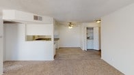 Located at 444 E 4th Ave, Unit #1010 in Escondido, this single-floor residence offers a clean, functional layout designed for comfortable everyday living. The open living area is generously proportioned, featuring neutral carpet, a textured ceiling, a ceiling fan with light fixture, and a sliding glass door that invites natural light and outdoor access. A pass-through window connects the living space to the kitchen, enhancing the open feel between rooms.

The galley-style kitchen is efficiently organized with white cabinetry lining both sides, granite-look countertops, a double stainless steel sink, white appliances including a refrigerator and range, and wood-look flooring. A dedicated laundry area with washer and dryer hookups is conveniently accessible from the main living space.

The bedrooms are carpeted and bright, each benefiting from large windows with vertical blinds that allow natural light while maintaining privacy. The textured ceilings and neutral white walls provide a clean, versatile backdrop throughout.

Two bathrooms serve the unit. One features a granite-look vanity countertop, a large wall mirror, and a tiled tub-shower combo. The second bathroom mirrors this design with a single-sink vanity, wood-look flooring, and a tiled tub-shower combination with a chrome grab bar. Both bathrooms are finished in a consistent, neutral palette.