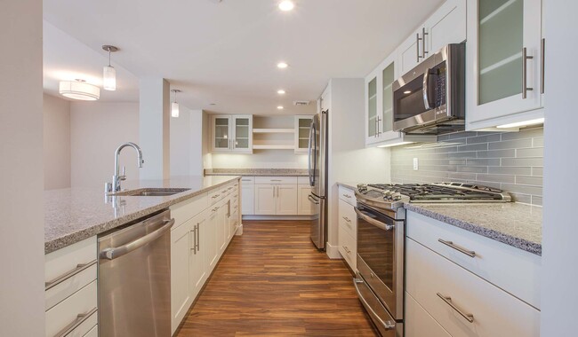 Kitchen with spacious, quartz countertops, stainless steel appliances, frosted glass cabinets, and soft-close drawers - Ocean House on Prospect Apartment Homes