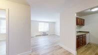Located at 6871 Ames Rd in Parma, Ohio, this single-floor, one-bedroom, one-bathroom unit offers a clean and efficient layout designed to maximize every square foot. Throughout the space, light wood-look flooring provides a cohesive, modern aesthetic that brightens each room.

The living room is the largest area of the unit, featuring crisp white walls, a window with natural light, a baseboard heating system, and a wall-mounted air conditioning unit for year-round climate control. The open, airy feel of the space makes it versatile for various furniture arrangements.

The bedroom is a well-proportioned private retreat, also featuring light wood-look flooring, a window with blinds, a ceiling fan, and baseboard heating. Neutral tones throughout create a calm and restful atmosphere.

The kitchen is efficiently designed with rich cherry-toned wood cabinetry, granite-look countertops, a single-basin stainless steel sink, and a white electric range. Ample upper and lower cabinet storage ensures practical functionality.

The bathroom is neatly appointed with a sliding-door shower enclosure, a wood-toned vanity with a light countertop, a medicine cabinet mirror, and matching wood-look flooring that ties the space together seamlessly. The overall unit presents a tidy, move-in-ready condition throughout.
