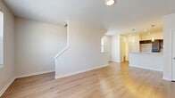 This three-floor, one-bedroom, two-bathroom home at 2231 E 89th St in Cleveland, Ohio offers a well-organized layout spread across multiple levels. The main living floor features an open-concept kitchen and living room combination finished with light hardwood flooring that reflects natural light from large windows. The kitchen is appointed with rich dark espresso cabinetry, white quartz countertops, stainless steel appliances, and a peninsula with pendant lighting — a functional and stylish centerpiece of the home. The living area is bright and airy, equipped with a wall-mounted mini-split unit for climate control. A striking staircase with dark wood treads and white risers connects the floors, adding a contemporary architectural touch. The upper level hosts the spacious primary bedroom, carpeted for comfort, alongside a hallway, two closets, and a full bathroom. Additional practical spaces include a dedicated laundry room, pantry, utility room, and entrance foyer. One bathroom features neutral tile flooring with clean, minimal finishes. Throughout the home, a consistent palette of white walls, light wood floors, and modern hardware creates a cohesive and move-in-ready aesthetic well-suited for urban living in Cleveland.