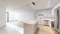 Located at 13045 Tesson Ferry Rd in Saint Louis, Missouri, this single-floor residence offers a clean, contemporary design highlighted by an open-concept layout and a bright, neutral color palette throughout. The kitchen serves as the centerpiece of the living space, showcasing white shaker-style cabinetry with matte black hardware, a classic subway tile backsplash, light quartz countertops, and a large center island ideal for dining or entertaining. A full suite of stainless steel appliances — including a refrigerator, range, microwave, and dishwasher — completes the kitchen. Light-toned hardwood flooring extends throughout the main living and kitchen areas, lending warmth and continuity to the space. Track and pendant lighting provide both ambient and task illumination. The bedroom features plush carpeting and generous closet space with built-in shelving for organized storage. The bathroom is well-appointed with a dual-sink vanity topped in white quartz, matte black fixtures, a large mirror, and a glass-enclosed shower. A dedicated laundry room houses a full-size front-loading washer and dryer with overhead shelving. The overall ambiance is modern, clean, and move-in ready.