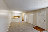 Located at 10530 Florida Blvd in Baton Rouge, Louisiana, this one-bedroom, one-bathroom unit offers a practical and well-organized single-floor layout. The combined living and dining area serves as the heart of the home, featuring plush neutral-toned carpet, a textured ceiling, and a decorative chandelier that adds a touch of warmth. A pass-through counter connects this open area to the kitchen, promoting a sense of openness between the spaces. The kitchen is efficiently designed with wood-look flooring, white cabinetry providing ample storage, a double-basin sink, and a full-size refrigerator. A pantry offers additional storage convenience. The bedroom is a comfortable and well-sized retreat, carpeted in neutral tones and featuring a window that allows natural light to fill the room. Multiple closets throughout the unit — including a sliding-door closet — provide generous storage options. The bathroom includes a vanity with under-sink cabinetry, a wall mirror, and wood-look flooring. The unit's consistent neutral color palette and practical layout create a clean, functional living environment suitable for everyday comfort.