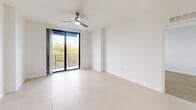 Located at 2101 Ludlam Rd in Miami, FL, this two-bedroom, two-bathroom residence offers a well-designed single-floor layout with a clean, contemporary aesthetic throughout. The open kitchen is a standout feature, equipped with white shaker cabinetry, granite countertops, a subway tile backsplash, stainless steel appliances including a full-size refrigerator, electric range, and built-in microwave, complemented by pendant lighting and a double-basin sink. Large-format porcelain tile flooring runs through the kitchen and main living areas, while the bedrooms feature warm light wood-tone flooring. The spacious primary bedroom includes a walk-in closet with wire shelving and direct access to one of the bathrooms. A ceiling fan provides additional comfort in each bedroom. The living area opens to a private balcony through sliding glass doors, offering views of surrounding greenery and bringing in abundant natural light. Both bathrooms are finished with granite-topped white vanities, large-format tile surrounds, and combination tub/shower fixtures. A hallway connects the rooms efficiently, contributing to a functional and cohesive floor plan. The bright, neutral color palette and modern finishes create a clean, inviting atmosphere throughout the residence.