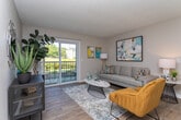 Located at 1369B Lees Chapel Rd in Greensboro, NC, this single-story unit offers a well-organized layout designed for comfortable everyday living. The living room serves as the central gathering space, featuring wood-style flooring, neutral walls, and a textured ceiling. A large sliding glass door floods the room with natural light and opens directly onto a private balcony overlooking green outdoor scenery, creating a seamless indoor-outdoor connection.

Adjacent to the living area is a dedicated dining nook, an intimate space well-suited for a small table and chairs, with wall space that accommodates decorative artwork. The kitchen is outfitted with white shaker-style cabinetry, granite-look countertops, a stainless steel double sink, and black appliances including a refrigerator and dishwasher. Light wood-style flooring ties the kitchen and adjacent areas together cohesively.

The unit includes two bedrooms, each featuring plush carpeting, neutral tones, a textured ceiling, and windows that bring in natural light. Both rooms offer a calm, restful atmosphere with ample wall space. Two full bathrooms serve the unit, each equipped with a tub-shower combination and wood-style flooring, finished in clean, bright white tones for a fresh, functional aesthetic throughout.