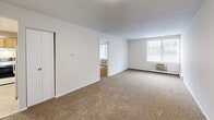 Located at 185 New Ludlow Rd in Chicopee, Massachusetts, this single-floor unit offers a functional and straightforward layout with two bedrooms and two bathrooms. The living area features neutral-toned wall-to-wall carpeting, clean white walls, and windows that bring in natural light, creating a bright and open feel. A baseboard heating system and wall-mounted AC unit provide year-round climate control.

The kitchen is equipped with warm oak cabinetry, ample counter space with neutral laminate countertops, a coil-burner electric range with an overhead ventilation hood, and a stainless steel sink — offering a practical and efficient cooking space.

The spacious primary bedroom includes its own connected bathroom, adding a level of privacy and convenience. The en-suite bathroom features a white vanity with under-cabinet storage and a well-lit mirror. A second full bathroom is also present, complete with a tub-shower combination and tile flooring.

The second bedroom is generously sized with a bright window, carpeted flooring, and a baseboard heater. Additional storage is available through closets found throughout the unit. The overall aesthetic is clean, neutral, and move-in ready, making this a practical and comfortable living space.