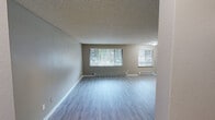 This 870 square foot apartment in Lakewood, Washington offers a practical and contemporary living space. The layout features two bedrooms and two bathrooms, providing comfort and privacy. The primary bedroom is generously sized at 180 square feet, offering ample space for rest and relaxation.

The kitchen is a highlight, showcasing modern white cabinetry, light-colored countertops, and stainless steel appliances. A sliding glass door in the kitchen area leads to an outdoor space, allowing natural light to flood in and providing easy access for outdoor dining or relaxation.

Both bedrooms are carpeted for comfort and feature ceiling fans for improved air circulation. Large sliding closet doors in the bedrooms offer extensive storage options. The bathrooms are updated with clean, white fixtures and modern shower units.

Throughout the apartment, neutral-toned walls create a bright, airy atmosphere. The living areas boast wood-look flooring, adding a touch of warmth to the space. Recessed lighting and modern light fixtures provide ample illumination.

The efficient floor plan maximizes the use of space, with a hallway connecting the various rooms. Overall, this apartment combines functionality with contemporary design elements, creating a comfortable and stylish living environment.