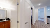 Located in Philadelphia's historic Old City neighborhood, Unit 2E at 22 N Front Street is a well-appointed two-bedroom, two-bathroom residence offering a thoughtfully designed single-level floor plan. Light-toned hardwood-style flooring runs throughout the main living areas, lending a clean, cohesive aesthetic.

The open-concept kitchen is a standout feature, equipped with rich warm-toned wood cabinetry, dark granite countertops, and a full suite of stainless steel appliances including a gas range, microwave, and refrigerator. A breakfast bar with a dark granite overhang provides additional seating and connects the kitchen seamlessly to the living area.

The spacious living room is bathed in natural light through large multi-pane French doors that open to a private balcony with views of the surrounding brick architecture. A second set of windows brightens the adjacent area further.

The generously sized primary bedroom offers ample space, while the second bedroom features its own window with natural light. Both bathrooms are finished in clean white tile; one includes a full tub-shower combo with subway tile surround and chrome fixtures, while the second is a bright, open space with light tile flooring. The unit's crisp white walls and neutral palette throughout create a bright, move-in-ready environment.