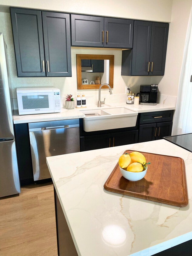 Cocina con fregadero estilo granja, microondas, gabinetes nuevos, encimeras, lavavajillas, cafetera Keurig. - 1795 W 28th St