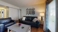 Located at 650 Bentley Ridge Blvd in Lancaster, PA, this well-appointed single-floor unit offers a functional and comfortable layout throughout. Rich hardwood flooring flows through the main living areas, creating a warm and cohesive aesthetic from the entry hallway to the living and dining spaces.

The living room is a welcoming focal point, featuring natural light from French doors that open to the outdoors, complemented by neutral walls and tasteful décor. An in-unit washer and dryer area is conveniently accessible from this space. Adjacent to the living room, the dining area accommodates a generous round table with ample seating, centered beneath a pendant light fixture.

The kitchen is equipped with stainless steel appliances, including a range, dishwasher, and over-the-range microwave, alongside warm oak cabinetry and granite-style countertops, offering both style and practicality. Light hardwood flooring continues throughout the kitchen area.

Two comfortable bedrooms provide restful retreats, each carpeted and filled with natural light from well-placed windows. The primary bedroom is notably spacious, while the second bedroom includes a wall-mounted television.

Two full bathrooms serve the unit, each featuring a tub/shower combination with a vanity and hardwood-style flooring. The overall layout is thoughtfully designed to maximize both functionality and comfort.