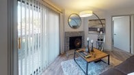 Located at 300 Hickory Hollow Pl in Nashville, Tennessee, this single-story residence offers a well-designed layout with a cohesive, contemporary aesthetic throughout. The living room serves as a central gathering space, highlighted by a striking stone fireplace and floor-to-ceiling vertical blinds that allow generous natural light while offering views of the outdoors. Wood-look flooring flows through the main living and dining areas, adding warmth and continuity. The dining area accommodates a round glass-top table beneath a pendant light fixture and features a built-in shelving nook for added storage and display. The galley-style kitchen is efficiently organized with gray cabinetry lining both sides, white countertops, and stainless steel appliances, including a range, microwave, and refrigerator. The residence includes multiple bedrooms, each carpeted for comfort and outfitted with natural light from windows. Closets with louvered doors provide practical storage in the secondary bedrooms, while the primary bedroom offers a more refined atmosphere. Two full bathrooms feature tub-shower combinations, vanities with light countertops, and textured walls. The overall ambiance is functional yet stylish, making this Nashville residence a comfortable and well-appointed home.