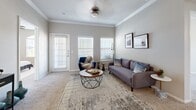 This single-floor, 2-bedroom, 2-bathroom residence is thoughtfully designed to maximize comfort and functionality. The open-plan living and dining area serves as the heart of the home, featuring plush carpet flooring, crown molding, and a ceiling fan. Large windows along the exterior wall flood the space with natural light and offer outdoor views, while a track lighting system and pendant fixtures provide additional illumination. The living area connects seamlessly to a dedicated dining space.

The kitchen features light wood cabinetry, granite-style countertops, tile flooring, and a peninsula that opens toward the dining area — ideal for both cooking and entertaining. A pantry and in-unit laundry area add to the home's practicality.

The primary bedroom is generously sized, highlighted by an arched window that brings in ample natural light, carpet flooring, and a ceiling fan. It is complemented by a private en-suite bathroom with a walk-in shower, tile flooring, and a spacious walk-in closet fitted with wire shelving systems. The second bedroom is equally well-appointed with its own ceiling fan and comfortable proportions. A second full bathroom with a glass-enclosed shower serves this bedroom and guests. Three closets throughout the home ensure abundant storage.
