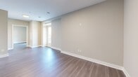 Located on the 18th floor at 195 Dundas St in downtown London, Ontario, this modern one-bedroom, one-bathroom unit offers a well-designed layout with contemporary finishes throughout. The open-concept kitchen is a standout feature, equipped with stainless steel appliances including a French door refrigerator, electric range, and built-in microwave. Crisp white cabinetry with subway tile backsplash and a large central island with a quartz countertop provide ample prep and storage space, while warm-toned laminate flooring ties the space together seamlessly. The living area is bright and open, with neutral walls and large windows that invite natural light and frame expansive views of the London cityscape. The bedroom is comfortably sized, featuring a large double-door closet, laminate flooring, and a floor-to-ceiling window overlooking the city below. The bathroom is finished with large-format tile flooring, a marble-accented tub surround, a modern vanity, and elegant accent lighting. A private balcony accessed through glass sliding doors offers stunning panoramic views of the London skyline and surrounding cityscape — a rare highlight at this elevation. The overall aesthetic is clean, contemporary, and move-in ready.