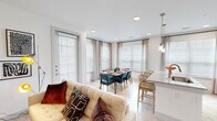 This well-appointed 2-bedroom, 2-bathroom residence combines modern design with functional living across a single, thoughtfully planned floor. The open-concept living and dining area is a standout feature, bathed in natural light through large windows dressed with elegant sheer curtains and wood blinds. Light hardwood-style flooring flows throughout the common areas, lending a clean, cohesive aesthetic. The dining space comfortably accommodates a full dining table and is framed by a bay of windows that create an airy, inviting atmosphere.

The kitchen is equipped with sleek gray shaker-style cabinetry, granite countertops, a subway tile backsplash, and stainless steel appliances, including a refrigerator with ice maker, range, and microwave. A breakfast bar provides additional seating and connects the kitchen to the living area.

Both bedrooms are carpeted for comfort and feature large windows with ample natural light, ceiling fans, and dedicated closets. The primary bedroom is generously sized, and its en-suite bathroom offers a dual-sink vanity with granite countertops, white cabinetry, and a glass-enclosed shower. The second bathroom mirrors the same refined finishes. Well-lit hallways connect the spaces, completing this polished and comfortable home.