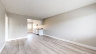 Located at 1311 N Azusa Ave in Azusa, CA, this 2-bedroom, 1-bathroom unit offers a well-organized single-level layout designed for comfortable everyday living. Light wood-style flooring runs consistently throughout the space, complemented by neutral warm-gray walls, crisp white baseboards, and textured ceilings that give each room a clean, cohesive feel.

The combined kitchen and living area forms the heart of the unit. The kitchen features white shaker-style cabinetry with brushed nickel hardware, dark countertops, a stainless steel sink, and a dishwasher. The adjacent living room benefits from a window that brings in natural light, with a wall-mounted air conditioning unit providing climate control.

Both bedrooms are comfortably sized, with the primary bedroom offering generous proportions, a ceiling fan with light fixture, a window with views of the surrounding area, and a sliding mirrored closet. The second bedroom is equally well-appointed with its own ceiling fan and ample natural light.

The bathroom is neatly finished with white cabinetry, dark countertops, gold-toned hardware, and a glass-door shower-tub combination. A hallway connects the rooms efficiently, contributing to the practical flow of the layout. Overall, the unit presents a modern, move-in-ready aesthetic throughout.