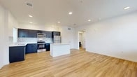 Located at 2525 S Meadows Rd in Santa Fe, New Mexico, this well-designed single-floor, one-bedroom, one-bathroom residence offers a clean, contemporary aesthetic throughout. The open-concept living and kitchen area serves as the heart of the home, featuring light wood-style flooring, recessed lighting, and a seamless flow that maximizes the sense of space. The kitchen is outfitted with dark cabinetry, white quartz countertops, a subway tile backsplash, and a full suite of stainless steel appliances including a refrigerator, electric range, built-in microwave, and dishwasher. A central kitchen island adds additional counter space and visual contrast. The living area is bright and open, with access to natural light through multiple windows and a door leading to the exterior. The bedroom is a comfortable, well-proportioned room with a ceiling fan, a window allowing natural light, and access to closet storage. The bathroom features a dark-cabinet vanity with a white countertop, a full tub-shower combination, and consistent wood-style flooring. Additional conveniences include a dedicated laundry area, two closets, and a hallway connecting all spaces. The unit presents a modern, move-in-ready interior with a cohesive neutral palette throughout.