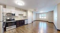 Located on Raymond Street in Norwalk, Connecticut, this two-bedroom, two-bathroom residence offers a well-organized single-floor layout designed for comfortable everyday living. The open-plan kitchen and living area serves as the heart of the home, featuring warm hardwood-style flooring that flows throughout the unit. The kitchen is outfitted with stainless steel appliances — including a refrigerator, range, microwave, and dishwasher — complemented by a two-tone cabinet design with white upper cabinets and dark lower cabinets, providing ample storage and a clean, modern aesthetic. Track lighting and flush-mount ceiling fixtures keep the space bright and functional. Both bedrooms are generously proportioned, with neutral walls, wood-style flooring, and multiple windows fitted with horizontal blinds that invite natural light while maintaining privacy. The primary bedroom offers a comfortable footprint with views of the surrounding neighborhood. The two bathrooms are finished with neutral tile flooring and feature white shaker-style cabinetry, a vanity with mirror, and a tub/shower combination. The overall ambiance is clean, modern, and move-in ready, with a consistent neutral palette that offers a versatile backdrop for any décor style.