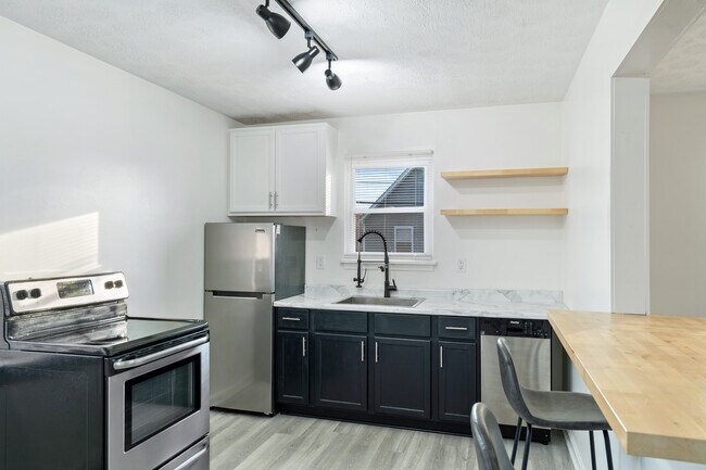 Kitchen with stainless steel appliances and butcher block. - 618 E 5th Street