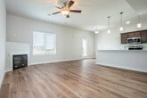 Located at 2647 Botanical Dr in Fitchburg, WI, this three-bedroom, four-bathroom home spans three floors, offering a well-organized and functional layout. The main living level features an open-concept dining and living room anchored by a sleek modern fireplace and light hardwood flooring that lends a warm, contemporary feel. The kitchen is outfitted with stainless steel appliances including a refrigerator, range, and built-in microwave, complemented by dark cabinetry, quartz countertops, a double sink, and a pantry for added storage. Natural light flows in through a window-facing entry door, enhancing the bright, clean aesthetic throughout. The upper floor houses the three bedrooms, including a spacious primary suite, and is served by well-appointed bathrooms featuring dual-sink vanities with dark wood cabinetry, quartz countertops, and tub-shower combinations with light hardwood-style flooring. A dedicated in-unit laundry room with a full washer and dryer adds everyday convenience. The home also includes six closets with wire shelving for ample storage. The lower level offers an attached garage and an unfinished basement with a sump pump, providing significant potential for future finishing or storage use.