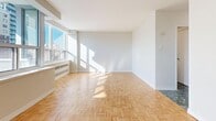 Located at 100 Roehampton Ave in Toronto's Midtown neighbourhood, this efficiently designed studio unit offers a well-considered layout across a single floor. The bright living area is a standout feature, showcasing classic parquet wood flooring in a herringbone pattern and large windows that flood the space with natural light while framing views of the surrounding Toronto skyline. A private balcony extends the living space outdoors, offering an additional vantage point over the city.

The kitchen is outfitted with rich dark wood cabinetry, white quartz countertops, a white tile backsplash, a stainless steel sink with a modern faucet, and an electric range — providing a functional and stylish cooking space. Two closets offer practical storage solutions within the unit.

The bathroom features distinctive dark marble-style tile flooring, a sleek vanity with a white countertop and dark wood cabinetry, a mirrored medicine cabinet, and a full bathtub with tiled surround, creating a clean and contemporary feel. The entrance area transitions smoothly into the main living space, completing a cohesive and practical floor plan well-suited for city living.