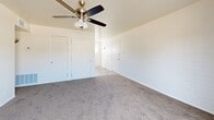 Located at 358 E Roeser Rd in Phoenix, AZ, this single-floor unit offers three bedrooms, one bathroom, and a hallway, all thoughtfully arranged within a compact but functional layout. The living and kitchen area features wood-look flooring, warm wood cabinetry, a white electric range, and light countertops, creating a practical and welcoming common space. Vertical blinds allow natural light to filter through while maintaining privacy.

The generously sized primary bedroom stands out as the largest room in the unit, offering ample space and featuring painted brick accent walls, plush carpeting, a ceiling fan with light fixture, and multiple closets — including a set of double bifold doors — providing excellent storage. The two additional bedrooms are similarly appointed with carpet flooring, painted brick walls, ceiling fans, and windows dressed with vertical blinds that invite natural light.

The bathroom is clean and functional, featuring a tiled tub-and-shower combination with warm beige wall tiles, a white vanity, and a window above the tub for natural ventilation. Throughout the unit, the consistent use of white-painted brick walls, neutral carpet tones, and ceiling fans creates a cohesive, low-maintenance aesthetic well-suited to the Phoenix climate.