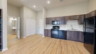 Located at 1020 Willowood St in Denton, Texas, this single-story 2-bedroom, 2-bathroom home offers a practical and well-designed layout. The kitchen is a standout feature, equipped with dark espresso cabinetry, black appliances including a range, microwave, dishwasher, and refrigerator, complemented by light countertops and wood-look luxury vinyl flooring that extends throughout the main living areas. Vaulted ceilings in the kitchen area add a sense of openness and volume to the space.

Both bedrooms are carpeted for comfort and feature tall ceilings, sliding closet doors, and windows that bring in natural light with views of the surrounding greenery. The primary bedroom offers a generous footprint with ample room for furnishings.

The two bathrooms each include a tub-shower combination with a curved curtain rod. One bathroom features a dark wood vanity with an undermount sink and white countertop, while the second offers a wall-mounted sink, both finished with the same wood-look flooring found throughout. Clean neutral wall tones and consistent finishes give the home a cohesive, move-in-ready aesthetic throughout.