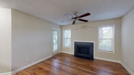 Located at 2696 N Druid Hills Rd NE in Atlanta, Georgia, this single-floor residence offers a well-appointed layout with a blend of practical design and comfortable living. The living room serves as the heart of the home, showcasing warm hardwood flooring, a striking black tile-surround fireplace, and multiple windows that invite an abundance of natural light. A ceiling fan overhead adds both style and functionality, while a glass-paned door provides direct access to the outdoors, framing views of surrounding greenery.

The kitchen is thoughtfully designed with dark cabinetry, stainless steel appliances including a range, microwave, and refrigerator, complemented by a mosaic tile backsplash and light granite countertops. A peninsula with an integrated sink offers additional prep space and a casual dining option, all illuminated by track lighting above.

The bedroom continues the home's comfortable aesthetic with plush carpeting, a ceiling fan, and a sliding glass door that opens to outdoor views, creating a bright and airy retreat. The bathroom features a clean, tiled tub-shower combination with classic white finishes. Throughout the space, neutral wall tones and consistent design choices create a cohesive and inviting atmosphere well-suited to everyday living in the heart of Atlanta.