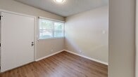 Located at 260 Brookwood Ave NE in Concord, NC, this two-story, 3-bedroom, 2-bathroom home offers a practical and well-organized layout distributed evenly across both floors. The main level features a bright living area with wood-look flooring, natural light from a front-facing window, and direct access to the pass-through kitchen. The kitchen is equipped with white cabinetry, gray countertops, stainless steel appliances including a dishwasher and range, and a double-basin sink — all finished with the same wood-look flooring that runs throughout the main level. A hallway off the living area connects the remaining spaces on this floor. Upstairs, the three bedrooms offer a mix of flooring options, with the primary bedroom featuring carpet and a ceiling fan, while an additional bedroom showcases rich dark hardwood-style flooring. Each bedroom is illuminated by natural light through window treatments. The two bathrooms are finished consistently with gray countertops, white cabinetry, and wood-look flooring. One bathroom includes a tub/shower combination with matte black hardware accents, while the second features a well-lit vanity with a mirror and modern light fixture. Textured ceilings are present throughout, adding a classic residential character to the home.