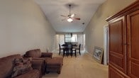 This single-story home at Princeton Place offers a well-organized layout with distinct living, dining, sleeping, and kitchen areas. The living room is a standout space, characterized by soaring vaulted ceilings and a ceiling fan overhead, creating an airy, open atmosphere. Neutral carpet and warm-toned walls carry throughout, lending a cohesive feel. A door provides natural light from outside, enhancing the room's openness.

The dining area flows naturally from the living room, featuring a ceiling-mounted light fixture and windows that brighten the space. Adjacent to it, the kitchen is efficiently arranged with warm oak cabinetry, white countertops, tile flooring, and stainless steel appliances including a refrigerator, electric range, and microwave.

The primary bedroom continues the vaulted ceiling design, includes a ceiling fan, and connects to a walk-in closet and private bathroom. A secondary bedroom with standard ceilings, a ceiling fan, and a window accommodates additional occupants comfortably. Two bathrooms serve the home, each featuring a tub-shower combination with tile flooring and warm neutral tones. Overall, the home delivers a practical and comfortable single-level living experience.