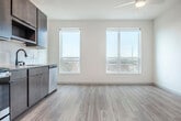 Located at 575 Zor Shrine Pl in Madison, WI, this thoughtfully designed single-floor unit offers a well-organized layout comprising a kitchen, living room, bathroom, and closet. Light-toned wood-look flooring runs throughout, creating a cohesive and clean aesthetic across every room.

The kitchen is a standout feature, showcasing rich dark-brown cabinetry that extends to the ceiling for ample storage, a white tile backsplash, and a full suite of stainless steel appliances including a refrigerator, range, microwave, and dishwasher. A window beside the kitchen fills the space with natural light and provides outdoor views.

The living area is bright and open, with crisp white walls, a ceiling fan with integrated lighting, and a window that invites in natural daylight. A wall-mounted mini-split HVAC unit ensures year-round climate comfort.

The bathroom is finished with a modern floating vanity in warm wood tones, a rectangular undermount sink, matte black fixtures, and a large mirror with built-in lighting. An open closet adjacent to the bathroom offers convenient built-in shelving for organized storage.

A clean, light-filled hallway with paneled white doors and matte black hardware connects the rooms, reinforcing the unit's contemporary and cohesive design throughout.