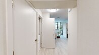 Located at 1698 University Ave in Berkeley, CA, this 2-bedroom, 1-bathroom unit offers a thoughtfully designed single-floor layout with a clean, modern aesthetic throughout. Light wood-tone flooring runs continuously across all rooms, complementing the crisp white walls and creating a bright, cohesive atmosphere.

The hallway serves as the central spine of the unit, connecting all rooms with efficient flow. The spacious primary bedroom is the standout space, offering generous room for a bed, dedicated workspace, and storage, with a large window framing greenery outside and admitting ample natural light. A full-height wardrobe provides substantial built-in storage. The second bedroom is equally well-appointed, featuring floor-to-ceiling black-framed windows that invite in natural light and tree views, paired with a built-in desk area and a mirrored wardrobe.

The kitchen is outfitted with white cabinetry, white appliances including a refrigerator, range, and microwave, and a practical U-shaped layout. A compact dining area sits adjacent, ideal for casual meals. The bathroom features light wood-look flooring, a shower-tub combo with a curtain, a wall-mounted vanity, and a small window for ventilation. The overall design is clean and contemporary, making efficient and comfortable use of the available space.