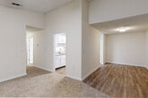 This single-floor residence offers a thoughtfully arranged layout with a clean, neutral palette throughout. The spacious living area features warm, textured carpeting and a ceiling fan with light kit, with a sliding glass door that opens onto a private deck overlooking lush greenery — bringing in abundant natural light and pleasant outdoor views.

The galley-style kitchen is well-equipped, showcasing white shaker cabinetry with brushed nickel hardware, granite-look countertops, a stainless steel sink, and a full suite of stainless steel appliances including a refrigerator, dishwasher, and electric range with exhaust hood. Additional storage is provided by a set of double closet doors within the kitchen.

Multiple bedrooms are carpeted and each include ceiling fans. One bedroom features a sliding window with outdoor views, while another offers a walk-in closet. The open transition area between rooms incorporates a mix of wood-look vinyl flooring and carpet, connecting the living spaces and kitchen seamlessly.

The bathroom is finished with wood-look vinyl flooring, white cabinetry, granite-look countertops, a mirrored medicine cabinet, and a tub-shower combo with clean white surrounds and brushed nickel fixtures. The overall interior presents a bright, move-in ready environment with consistent, modern finishes throughout.