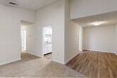 This single-floor residence offers a thoughtfully arranged layout with a clean, neutral palette throughout. The spacious living area features warm, textured carpeting and a ceiling fan with light kit, with a sliding glass door that opens onto a private deck overlooking lush greenery — bringing in abundant natural light and pleasant outdoor views.

The galley-style kitchen is well-equipped, showcasing white shaker cabinetry with brushed nickel hardware, granite-look countertops, a stainless steel sink, and a full suite of stainless steel appliances including a refrigerator, dishwasher, and electric range with exhaust hood. Additional storage is provided by a set of double closet doors within the kitchen.

Multiple bedrooms are carpeted and each include ceiling fans. One bedroom features a sliding window with outdoor views, while another offers a walk-in closet. The open transition area between rooms incorporates a mix of wood-look vinyl flooring and carpet, connecting the living spaces and kitchen seamlessly.

The bathroom is finished with wood-look vinyl flooring, white cabinetry, granite-look countertops, a mirrored medicine cabinet, and a tub-shower combo with clean white surrounds and brushed nickel fixtures. The overall interior presents a bright, move-in ready environment with consistent, modern finishes throughout.