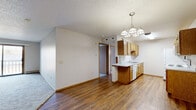 Located at 6500 W 43rd St in Sioux Falls, South Dakota, this 2-bedroom, 1-bathroom unit offers a functional and well-organized single-floor layout. The open-concept living and dining area features rich hardwood-style flooring and transitions seamlessly into carpeted zones, creating a comfortable and cohesive feel. A pendant chandelier adds a welcoming touch above the dining space, while a sliding glass door leads to a private balcony, bringing in natural light and outdoor access.

The kitchen is equipped with warm oak cabinetry, white appliances including a range, microwave, refrigerator, and dishwasher, and offers ample counter space with a convenient peninsula that opens to the living area. A textured ceiling runs throughout the main living spaces, adding a classic character to the interior.

Both bedrooms are carpeted and offer generous closet space with sliding wood-panel closet doors. The primary bedroom is a comfortable size, complemented by a baseboard heating unit. The second bedroom features a window that allows natural light to brighten the space.

The full bathroom includes an oak vanity with a white countertop, a tub-shower combination, and wood-look tile flooring. Clean and straightforward in design, this unit provides practical living in a convenient Sioux Falls location.