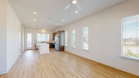 Located at 18131 Bluegrass Park Ln in Cypress, TX, this single-story, 2-bedroom, 2-bathroom home offers a thoughtfully designed layout with quality finishes throughout. The open-concept kitchen and living area forms the heart of the home, featuring light hardwood-style flooring, recessed lighting, and a ceiling fan overhead. The kitchen is equipped with rich medium-toned wood cabinetry, white quartz countertops, a tile backsplash, a central island, and a full suite of stainless steel appliances including a refrigerator, range, microwave, and dishwasher. Multiple windows fitted with blinds allow natural light to fill the space. The living area extends openly from the kitchen, providing a spacious and airy feel with a glass-paned front door adding additional light. Both bedrooms feature neutral carpet flooring and are served by dedicated closets with built-in shelving and hanging rods. The bathroom includes a wood-framed vanity mirror, white quartz countertop, and a shower-tub combination with a window above for natural light. A dedicated laundry room houses a full-size top-load washer and dryer. Clean white walls and consistent finishes create a cohesive, move-in-ready atmosphere throughout the home.