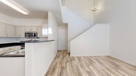 This two-story home in North Las Vegas offers a well-designed layout across two floors, with three bedrooms, three bathrooms, and two closets. The main floor features light wood-look vinyl flooring throughout, creating a bright and cohesive aesthetic. The open kitchen is equipped with stainless steel appliances — including a refrigerator, range, and microwave — complemented by white cabinetry and dark countertops. A breakfast bar connects the kitchen to the dining area, making the space ideal for everyday living and entertaining. A chandelier above the staircase adds a touch of elegance to the entry area, which flows naturally into the main living space.

Upstairs, the layout expands to include all three bedrooms, carpeted for comfort and warmth. The primary bedroom features soaring ceilings and a large window that fills the room with natural light. Additional bedrooms are generously proportioned, each with windows offering neighborhood views. The upper hallway is open to below, enhancing the sense of volume and airflow throughout the home.

The three bathrooms are clean and functional; one features a glass-enclosed tub and shower combination with wood-look flooring, while another offers a tiled tub-shower with curtain rod. The overall palette of white walls, neutral flooring, and modern fixtures gives the home a fresh, move-in-ready appeal.