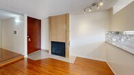 Located at 659 S Cloverdale Ave in the heart of Los Angeles, CA, this single-floor unit offers a well-organized layout with a comfortable flow throughout. The main living area is bright and open, featuring warm hardwood flooring, crisp white walls, and a textured ceiling. A standout architectural detail is the wood-paneled fireplace, which anchors the living space and adds a classic focal point near the entryway. Track lighting overhead provides functional illumination throughout.

The kitchen is thoughtfully appointed with white cabinetry offering generous storage, granite-style countertops, a stainless steel sink, and a mosaic tile backsplash that adds visual texture. The space includes a stainless electric range and an over-the-range microwave, making it a practical and well-equipped cooking area. Light tile flooring transitions seamlessly from the kitchen into adjacent areas.

The bathroom features a granite-topped vanity with an undermount sink, white cabinetry below, and a combined tub and shower with a curtain rod. Light tile flooring runs throughout the bathroom, contributing to a clean, neutral aesthetic. An adjacent closet with built-in shelving and a hanging rod provides convenient storage. The overall palette of whites and neutrals throughout the unit creates a clean, move-in ready environment.