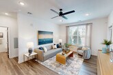 Located in Jacksonville, FL, this well-appointed 2-bedroom, 2-bathroom residence offers a thoughtfully designed single-floor layout that balances functionality with modern style. Wood-look flooring flows seamlessly throughout the home, creating a cohesive and contemporary aesthetic.

The open-concept kitchen and living area serves as the heart of the home. The kitchen features light wood cabinetry extending to the ceiling, white quartz countertops, a tile backsplash, and a full suite of stainless steel appliances including a range, microwave, and refrigerator with ice maker. A central island with bar seating provides additional prep space and casual dining options. The adjacent living room is bright and welcoming, with a large window framing outdoor greenery and recessed lighting overhead.

The primary bedroom offers a comfortable retreat with a ceiling fan, recessed lighting, and a generous walk-in closet equipped with built-in shelving and hanging rods. Its en-suite bathroom includes a glass-enclosed walk-in shower, a wood-toned vanity with white countertop, and clean, modern finishes. The second bedroom also features a ceiling fan and large window with natural light. The second bathroom mirrors the modern design with a shower/tub combination and a matching vanity. Two dedicated closets provide ample storage throughout the home.