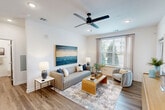 Located in Jacksonville, FL, this well-appointed 2-bedroom, 2-bathroom residence offers a thoughtfully designed single-floor layout that balances functionality with modern style. Wood-look flooring flows seamlessly throughout the home, creating a cohesive and contemporary aesthetic.

The open-concept kitchen and living area serves as the heart of the home. The kitchen features light wood cabinetry extending to the ceiling, white quartz countertops, a tile backsplash, and a full suite of stainless steel appliances including a range, microwave, and refrigerator with ice maker. A central island with bar seating provides additional prep space and casual dining options. The adjacent living room is bright and welcoming, with a large window framing outdoor greenery and recessed lighting overhead.

The primary bedroom offers a comfortable retreat with a ceiling fan, recessed lighting, and a generous walk-in closet equipped with built-in shelving and hanging rods. Its en-suite bathroom includes a glass-enclosed walk-in shower, a wood-toned vanity with white countertop, and clean, modern finishes. The second bedroom also features a ceiling fan and large window with natural light. The second bathroom mirrors the modern design with a shower/tub combination and a matching vanity. Two dedicated closets provide ample storage throughout the home.