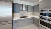Located in the heart of downtown Los Angeles, this modern high-rise residence at 225 S Olive St offers a thoughtfully designed open layout with premium finishes throughout. The expansive living area is anchored by wide-plank wood flooring and floor-to-ceiling sliding glass doors that open to a private balcony, flooding the interior with natural light and framing sweeping views of the Los Angeles skyline. A stylish barn-style sliding door adds an architectural accent to the living space.

The contemporary kitchen is outfitted with sleek grey cabinetry, white quartz countertops, a wood-toned tile backsplash, stainless steel appliances including a built-in double oven and a large panel refrigerator, a cooktop with a stainless steel range hood, and a dishwasher — ideal for both everyday living and entertaining.

The carpeted bedrooms are generously proportioned, each featuring ceiling fans and direct balcony access through sliding glass doors. One room features a wet bar with a built-in beverage refrigerator and a frosted glass sliding closet, providing flexible use as a guest suite or office.

The bathrooms are finished in neutral large-format tiles, featuring soaking tubs with glass enclosures, separate walk-in showers, illuminated vanity mirrors, and warm wood-toned cabinetry, creating a clean and spa-like atmosphere throughout.