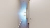 This 430-square-foot studio apartment is located at 1630 Southeast Rural Street, Unit 1-378, in Portland, Oregon. The single-floor layout is thoughtfully designed to maximize functionality within a compact footprint. Light-toned, wood-look luxury vinyl plank flooring runs throughout the entire unit, creating a cohesive and modern aesthetic.

The open living area features crisp white walls, clean baseboard trim, and large windows that flood the space with natural light and offer views of the surrounding building exterior. A wall-mounted HVAC unit provides climate control directly in the living space.

The kitchen is well-appointed with light wood cabinetry, white quartz countertops, and a white subway tile backsplash. Stainless steel appliances include a refrigerator, range with oven, over-the-range microwave, and dishwasher, offering a full suite of modern conveniences. Recessed lighting above the kitchen area adds to the clean, contemporary feel.

The bedroom area includes a dedicated closet fitted with a sliding door and a hanging rod, offering practical storage. A bathroom is also present, visible in the floor plan view. The overall design palette of whites, warm wood tones, and stainless steel gives this studio a bright, contemporary ambiance well-suited for efficient urban living.
