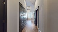 This contemporary 810 square foot single-floor residence offers a thoughtfully designed living space that maximizes functionality and natural illumination. The focal point of the home is its expansive open-plan living area, which seamlessly integrates the kitchen and living room. The space is characterized by its striking high ceilings, creating a sense of airiness and amplifying the overall spaciousness.

A standout feature is the set of large French doors, adorned with horizontal blinds, that serve as a gateway to the outdoors. These doors not only provide easy access to an exterior area but also flood the interior with an abundance of natural light, enhancing the bright and welcoming atmosphere.

The flooring throughout is a high-quality laminate in a warm, wood-like finish, adding both durability and aesthetic appeal. The walls are painted in a neutral tone, offering a blank canvas for personalization. The room's clean lines and minimalist design contribute to its modern feel.

In addition to the main living area, the property includes a bathroom and a closet, completing the essential elements for comfortable single-floor living. This well-planned space is ideal for those seeking a contemporary, low-maintenance home with an emphasis on natural light and open living.